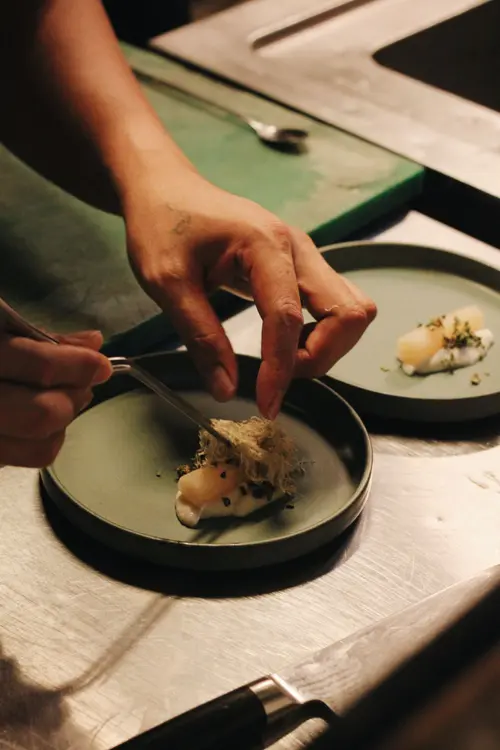 Chef plating a dish in the open kitchen