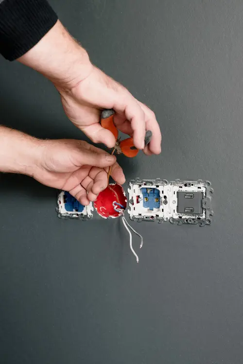 Electrician installing a new wall outlet
