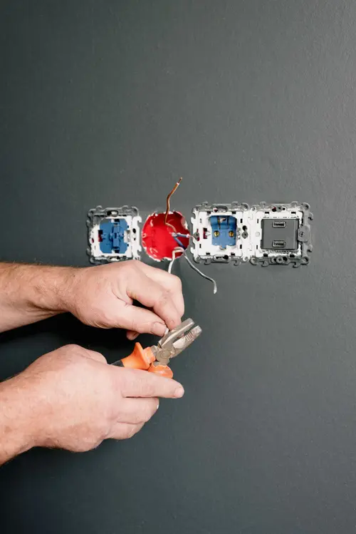 Close-up of an electrician wiring a wall outlet
