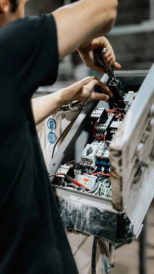 Electrician servicing an open control panel